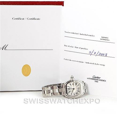 This image shows a Cartier Roadster W62016V3 Women's Stainless Steel Silver Dial W62016V3 Women's Stainless Steel Silver Dial watch lying flat beside its certification papers, photographed from an angled top view.