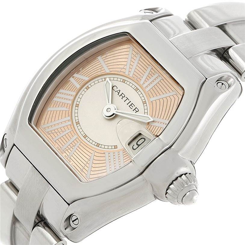 This image shows a close-up of the Cartier Roadster W62054V3 Women's Stainless Steel Pink Dial W62054V3 Women's Stainless Steel Pink Dial watch, including part of the case, crown, dial, and bracelet.