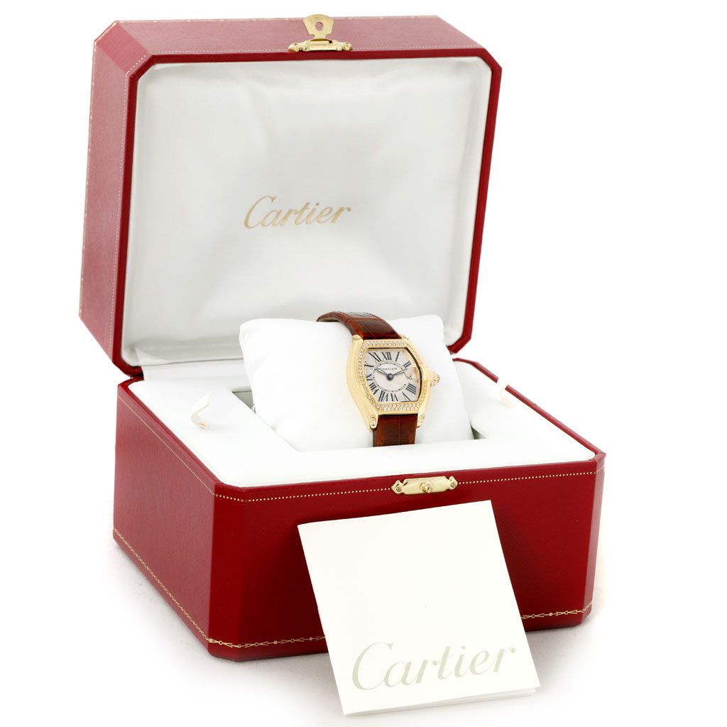 The Cartier Roadster WE500160 Women's Yellow Gold Silver Dial WE500160 Women's Yellow Gold Silver Dial watch is shown at a front angle inside an open red box with a Cartier-branded card in the foreground.