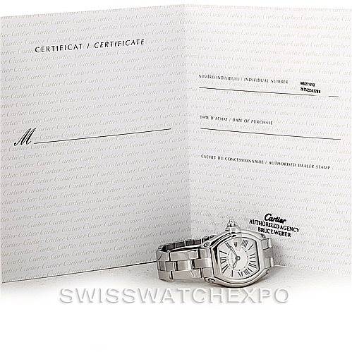 The image shows a Cartier Roadster W62016V3 Women's Stainless Steel Silver Dial W62016V3 Women's Stainless Steel Silver Dial watch laid next to its certification paperwork.