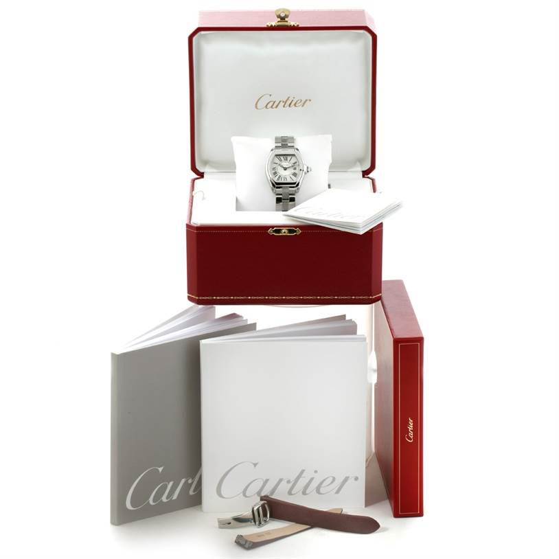 The image shows a Cartier Roadster W62016V3 Women's Stainless Steel Silver Dial W62016V3 Women's Stainless Steel Silver Dial watch in its red box with accompanying booklets, a brown leather strap, and tools.