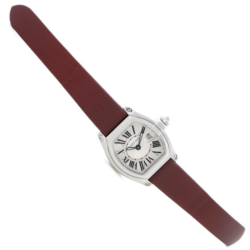 The Roadster model by Cartier is shown at a slight angled view, highlighting its dial, Roman numerals, date window, and burgundy strap.