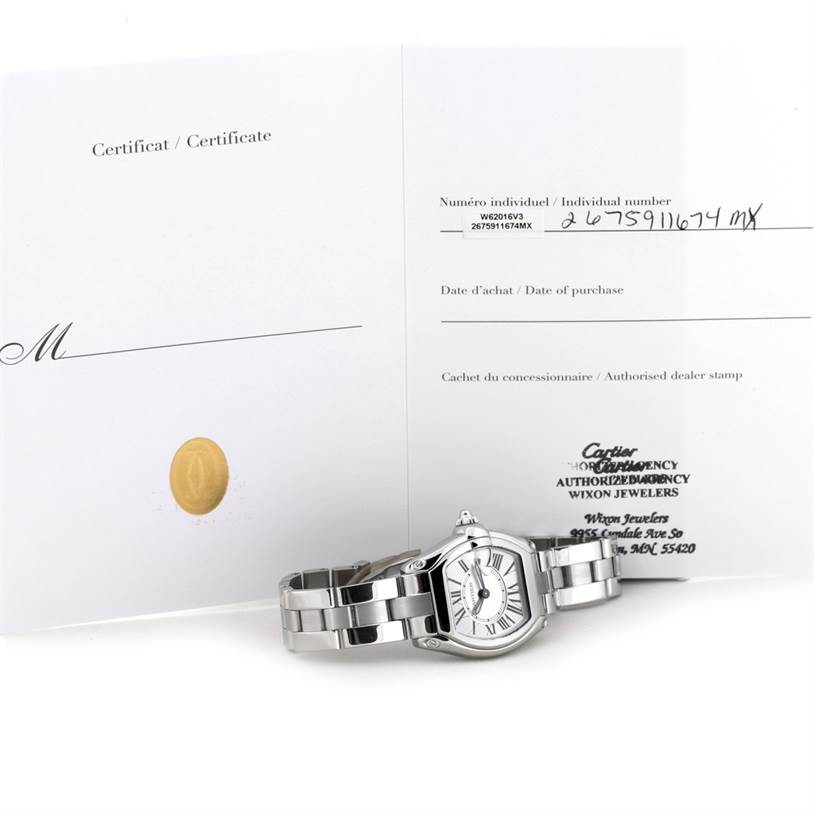 The Cartier Roadster W62016V3 Women's Stainless Steel Silver Dial W62016V3 Women's Stainless Steel Silver Dial watch is shown with its certificate and bracelet, viewed from an angled top-down perspective.