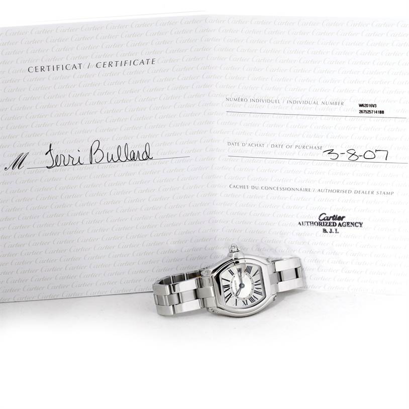 The Cartier Roadster W62016V3 Women's Stainless Steel Silver Dial W62016V3 Women's Stainless Steel Silver Dial watch is shown from a front angle with a certificate in the background.