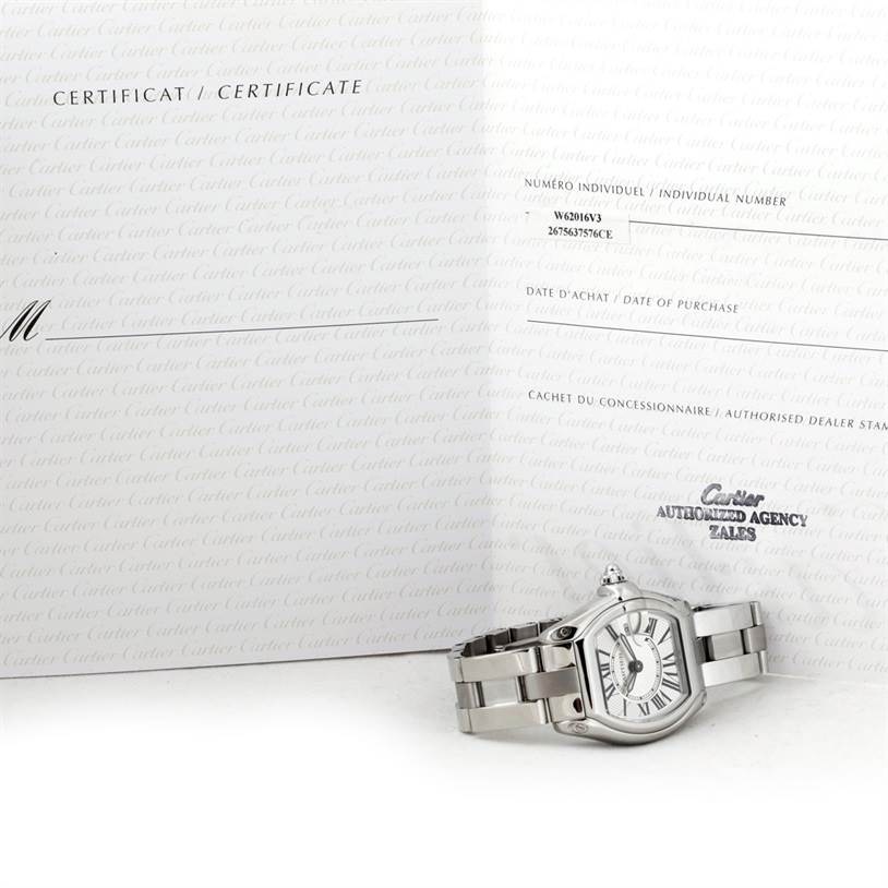 The Cartier Roadster W62016V3 Women's Stainless Steel Silver Dial W62016V3 Women's Stainless Steel Silver Dial watch is shown from a side angle with its certificate in the background.