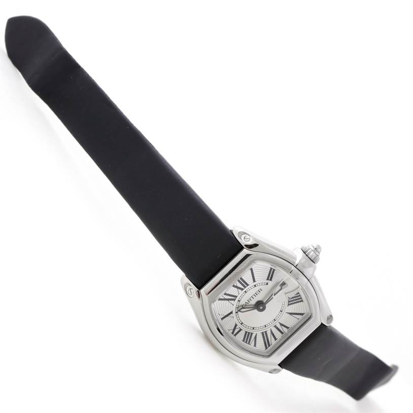 The Cartier Roadster W62016V3 Women's Stainless Steel Silver Dial W62016V3 Women's Stainless Steel Silver Dial watch is shown at an angle, displaying its black strap, silver case, and face with Roman numeral hour markers.