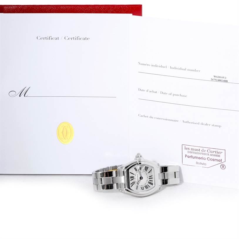 The image shows a Cartier Roadster W62016V3 Women's Stainless Steel Silver Dial W62016V3 Women's Stainless Steel Silver Dial watch lying flat with its certificate and purchase documents behind it.