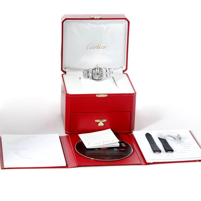 The Cartier Roadster W62016V3 Women's Stainless Steel Silver Dial W62016V3 Women's Stainless Steel Silver Dial watch is displayed in its original box, with accessories and documentation laid out in front.