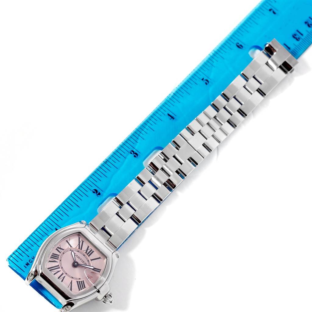 The image shows a Cartier Roadster W62017V3 Women's Stainless Steel Pink Dial W62017V3 Women's Stainless Steel Pink Dial watch laid flat alongside a ruler, displaying its face and metal bracelet.