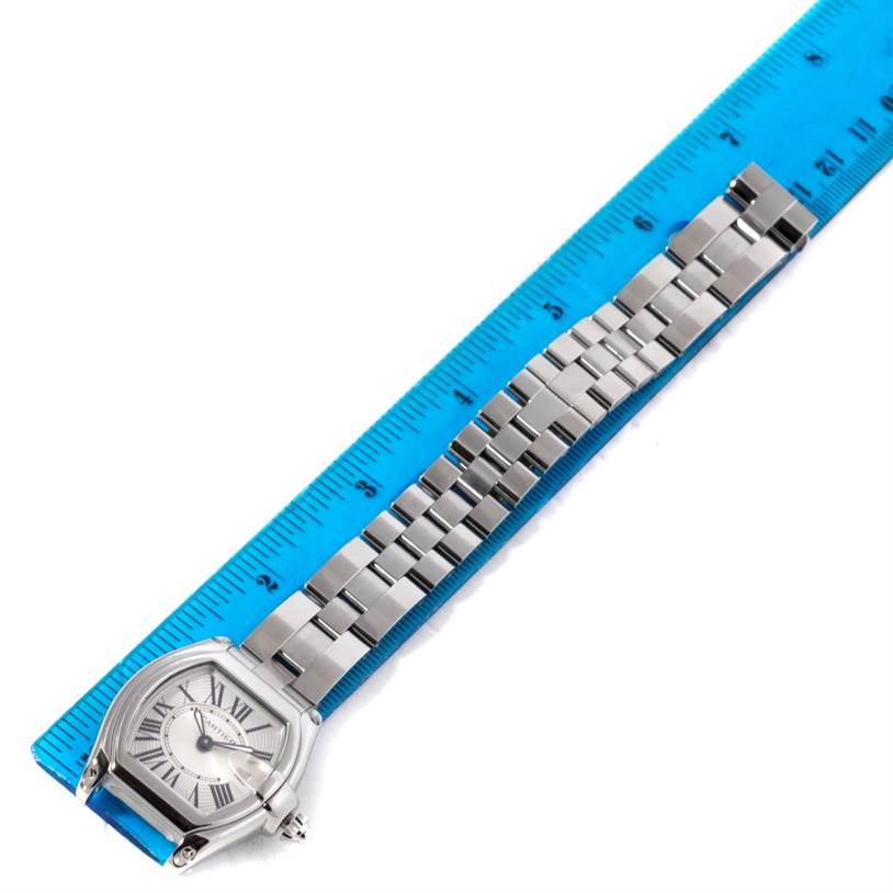 This image shows a Cartier Roadster W62016V3 Women's Stainless Steel Silver Dial W62016V3 Women's Stainless Steel Silver Dial watch laid next to a blue ruler for scale, displaying the face and metal bracelet.