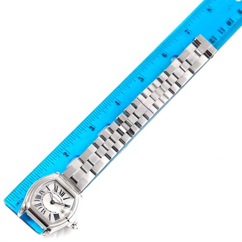 The image shows a Cartier Roadster W62016V3 Women
s Stainless Steel Silver Dial W62016V3 Women
s Stainless Steel Silver Dial watch from an overhead angle, placed next to a blue ruler.