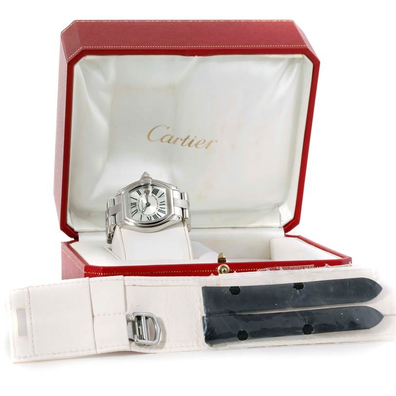 The Cartier Roadster W62016V3 Women
s Stainless Steel Silver Dial W62016V3 Women
s Stainless Steel Silver Dial watch is displayed in its red box, with additional straps shown in the forefront.