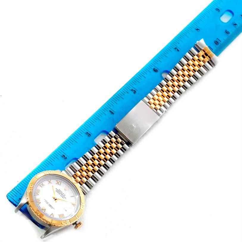 The Rolex Turn-o-Graph 16263 Men's Steel and Gold (two tone) White Dial 16263 Men's Steel and Gold (two tone) White Dial watch is shown from a top-down angle, with its face, bezel, and two-tone bracelet visible alongside a ruler for scale.