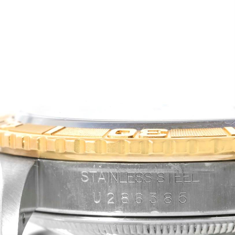The image shows a close-up of the Rolex Turn-o-Graph 16263 Men's Steel and Gold (two tone) White Dial 16263 Men's Steel and Gold (two tone) White Dial watch's gold bi-directional bezel and part of the stainless steel case with engravings.