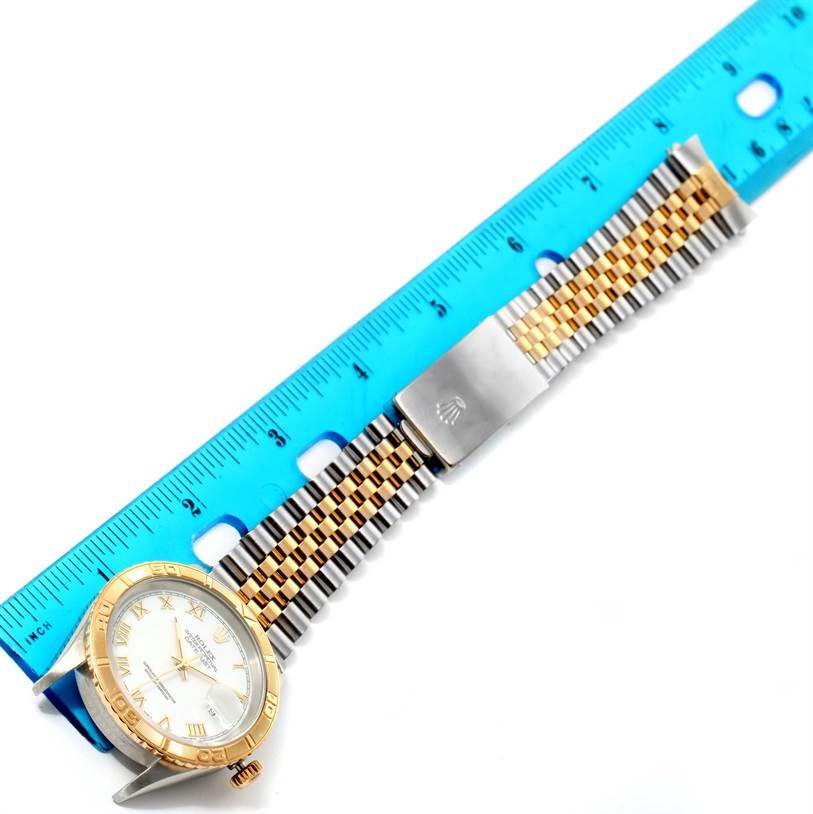 The image shows a Rolex Turn-o-Graph 16263 Men
s Steel and Gold (two tone) White Dial 16263 Men
s Steel and Gold (two tone) White Dial watch laid flat with a blue ruler beneath it, highlighting the face, bezel, and band.