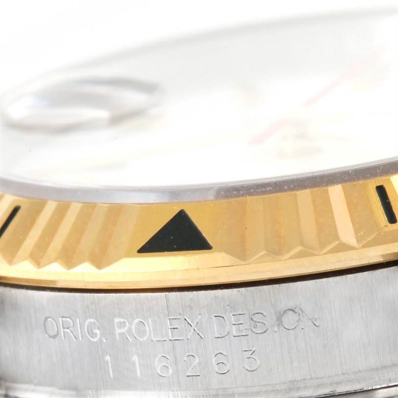 This close-up shows the bezel and part of the case of a Rolex Turn-o-Graph 116263 Men's Stainless Steel White Dial 116263 Men's Stainless Steel White Dial model, highlighting the fluted gold edge and engraved details.