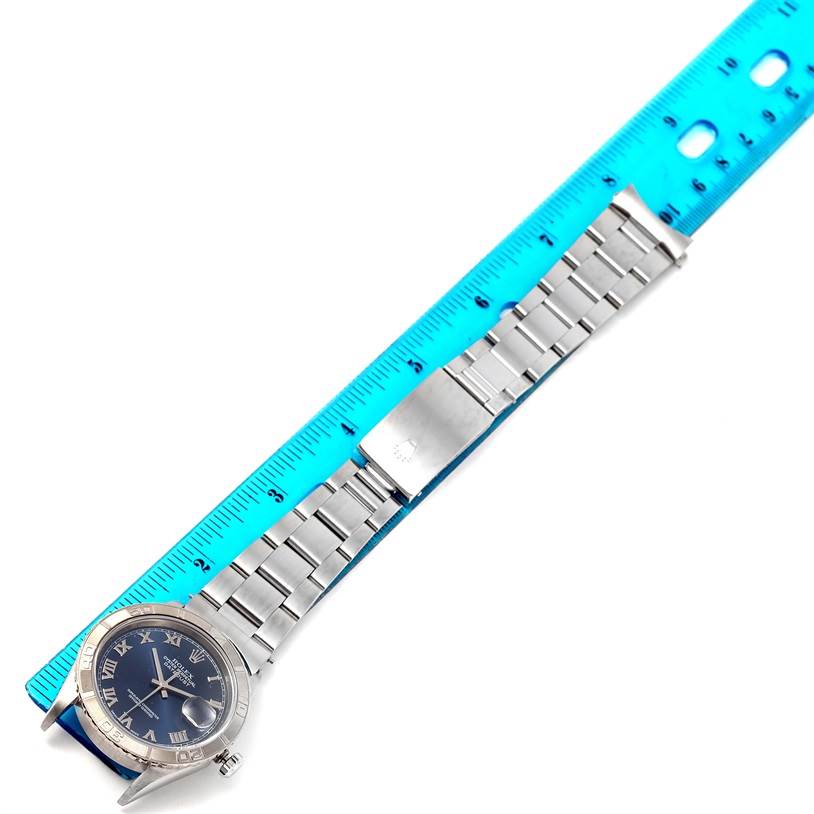 The image shows a Rolex Turn-o-Graph 16264 Men's Stainless Steel Blue Dial 16264 Men's Stainless Steel Blue Dial watch laid flat with a blue ruler measuring its metal bracelet.