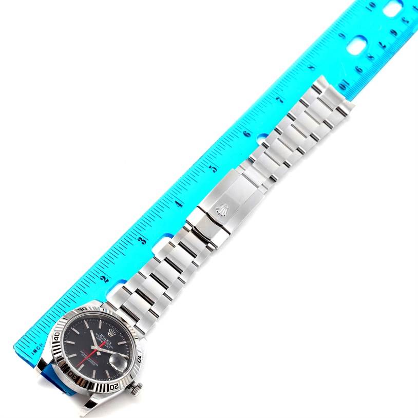 This image shows the Rolex Turn-o-Graph 116264 Men
s Stainless Steel Black Dial 116264 Men
s Stainless Steel Black Dial watch from a top-down angle, including its bracelet and clasp alongside a blue ruler.