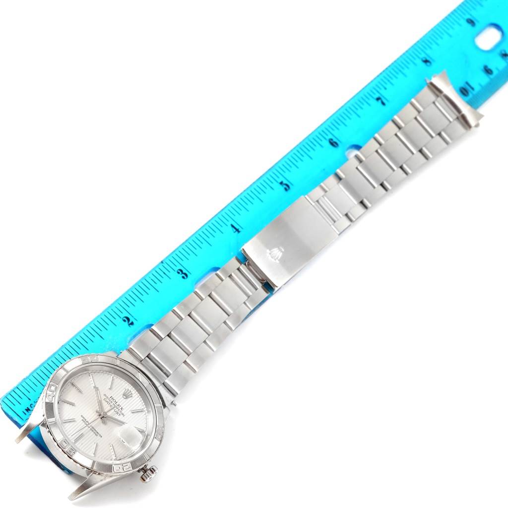 The image shows a top view of a Rolex Turn-o-Graph 16264 Men's Stainless Steel Silver Dial 16264 Men's Stainless Steel Silver Dial watch, displaying its face, bezel, bracelet, and clasp while aligned with a ruler.