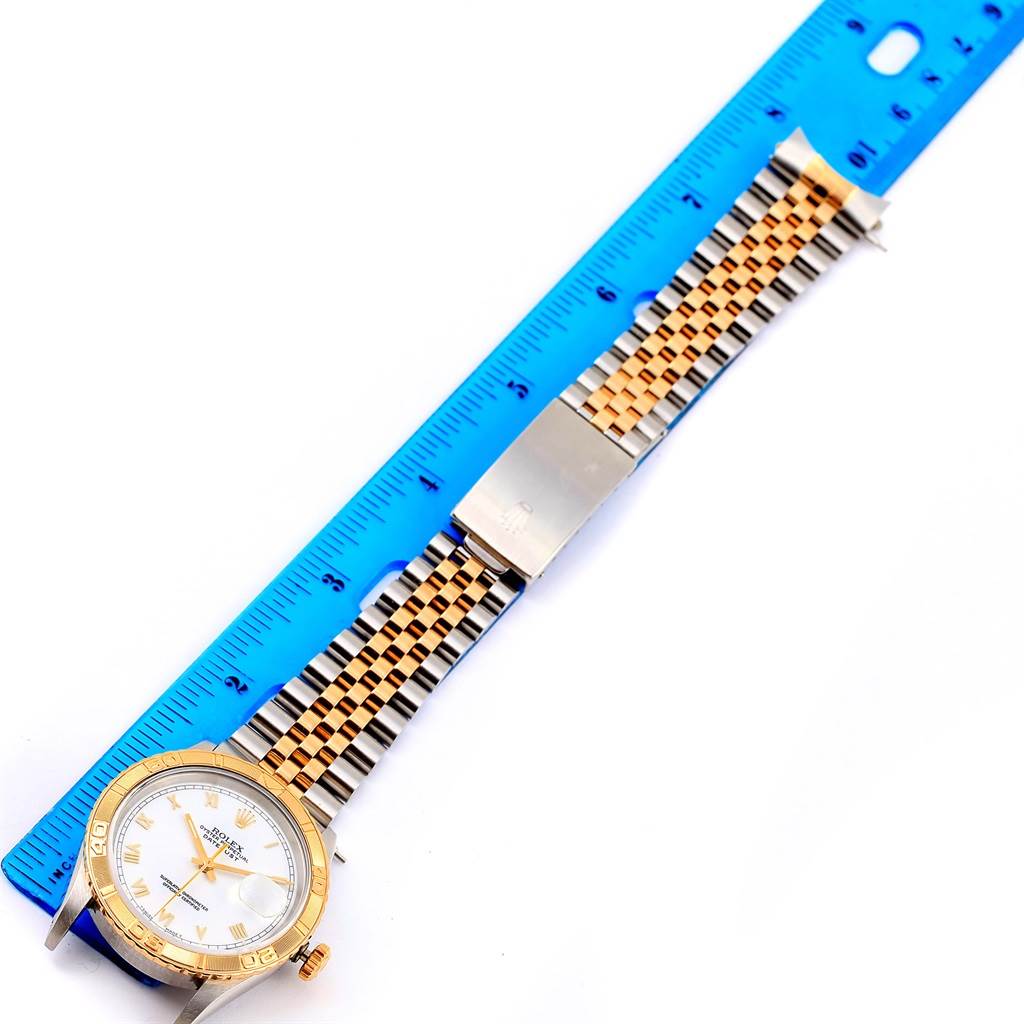 The image shows a Rolex Turn-o-Graph 16263 Men
s Steel and Gold (two tone) White Dial 16263 Men
s Steel and Gold (two tone) White Dial watch laid flat next to a blue ruler, displaying the face, bezel, band, and clasp.