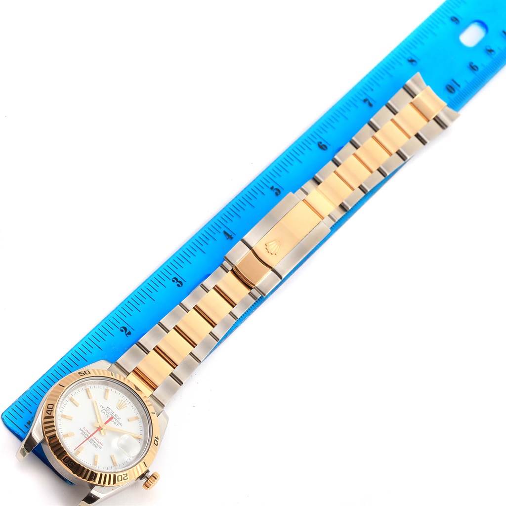 The image shows a Rolex Turn-o-Graph 116263 Men
s Stainless Steel White Dial 116263 Men
s Stainless Steel White Dial model watch laid flat next to a ruler, displaying its entire strap and face clearly.