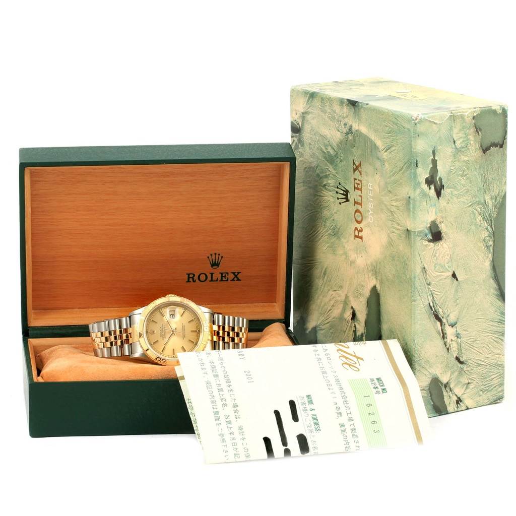 The image shows a Rolex Turn-o-Graph 16263 Men
s Steel and Gold (two tone) Champagne Dial 16263 Men
s Steel and Gold (two tone) Champagne Dial watch in an open display case with its outer box and accompanying documents.