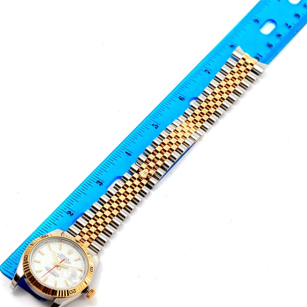 The Rolex Turn-o-Graph 116263 Men's Stainless Steel White Dial 116263 Men's Stainless Steel White Dial watch is shown from the top, highlighting its face, bezel, and two-tone bracelet next to a ruler.