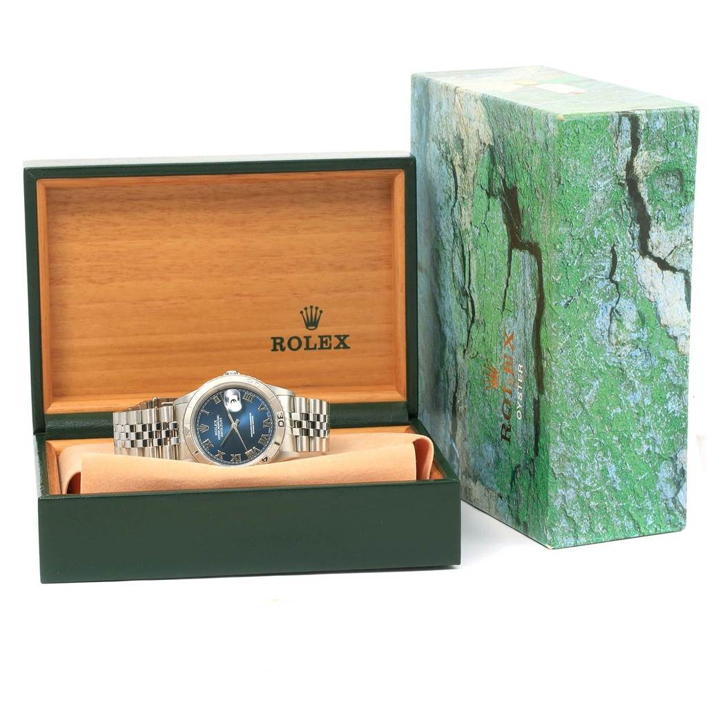 The Rolex Turn-o-Graph 16264 Men's Stainless Steel Blue Dial 16264 Men's Stainless Steel Blue Dial watch is shown front-facing in its open box with green and wooden elements.
