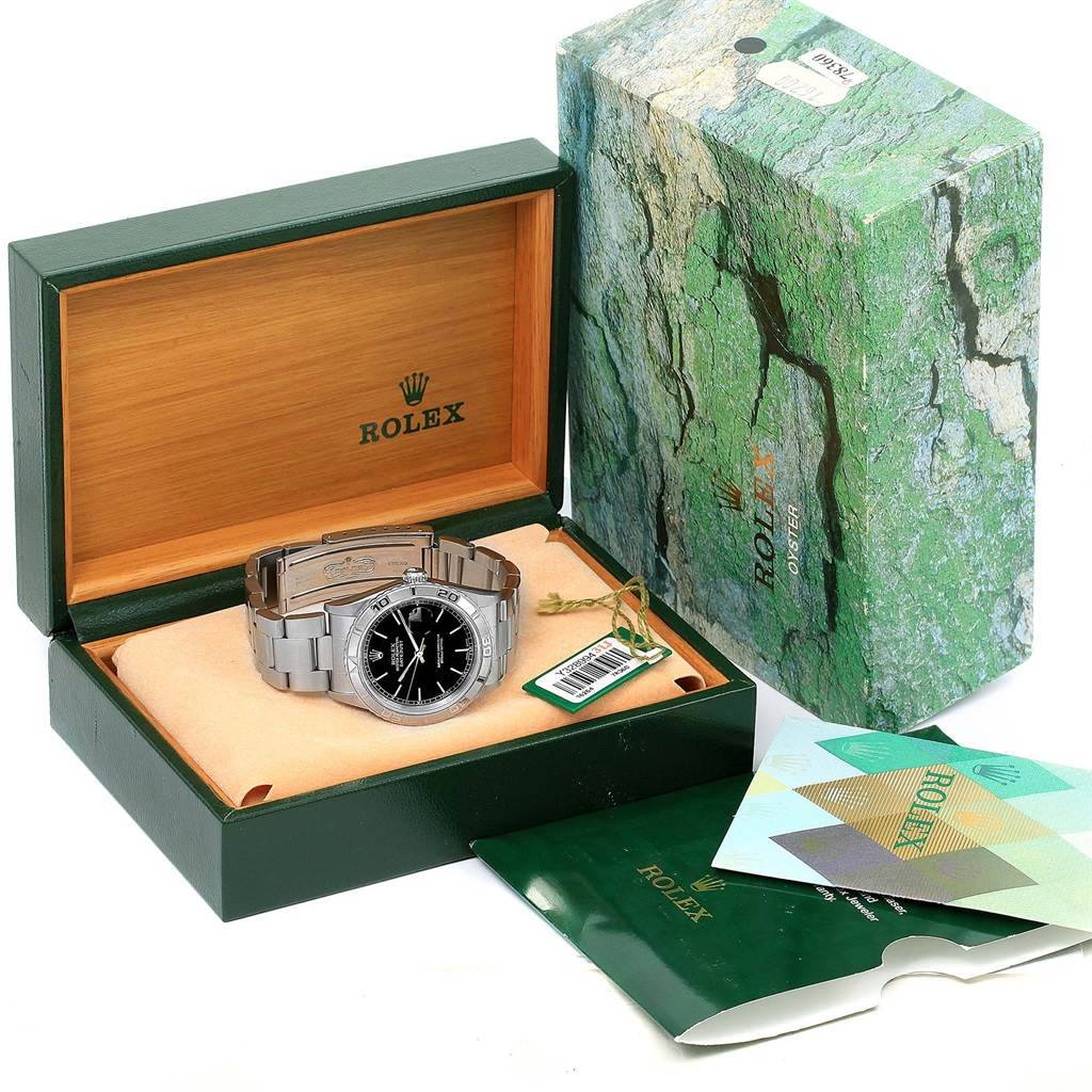 The Rolex Turn-o-Graph 16264 Men's Stainless Steel Black Dial 16264 Men's Stainless Steel Black Dial watch is displayed inside its open green box, with its packaging and booklets nearby.