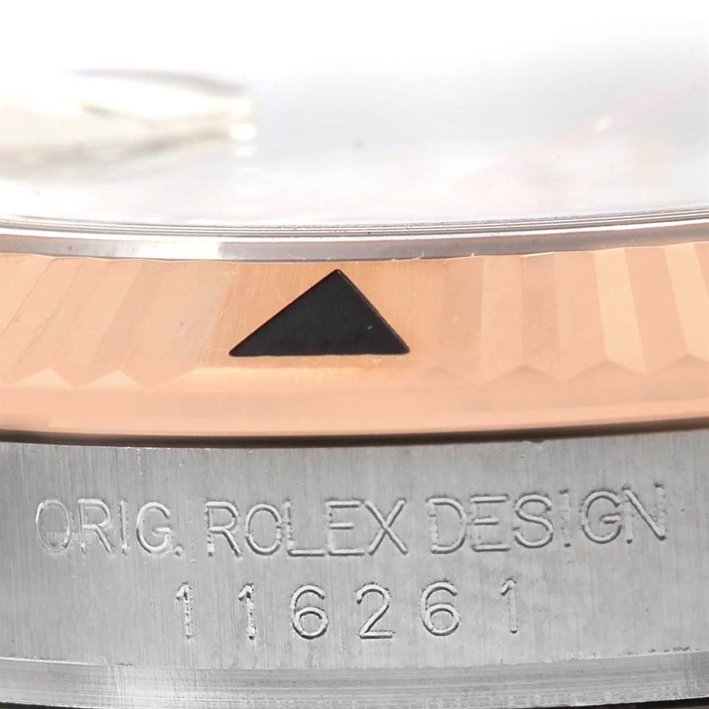 This close-up image of a Rolex Turn-o-Graph 116261 Men's Stainless Steel White Dial 116261 Men's Stainless Steel White Dial watch shows part of the bezel and the "ORIG. ROLEX DESIGN" engraving with model number 116261.