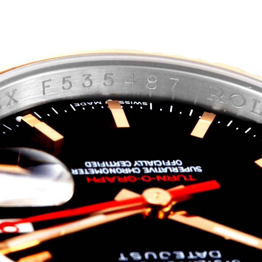 The image shows a close-up of the bezel, serial number, dial, and part of the hands of the Rolex Turn-o-Graph 116261 Men's Stainless Steel Black Dial 116261 Men's Stainless Steel Black Dial watch.