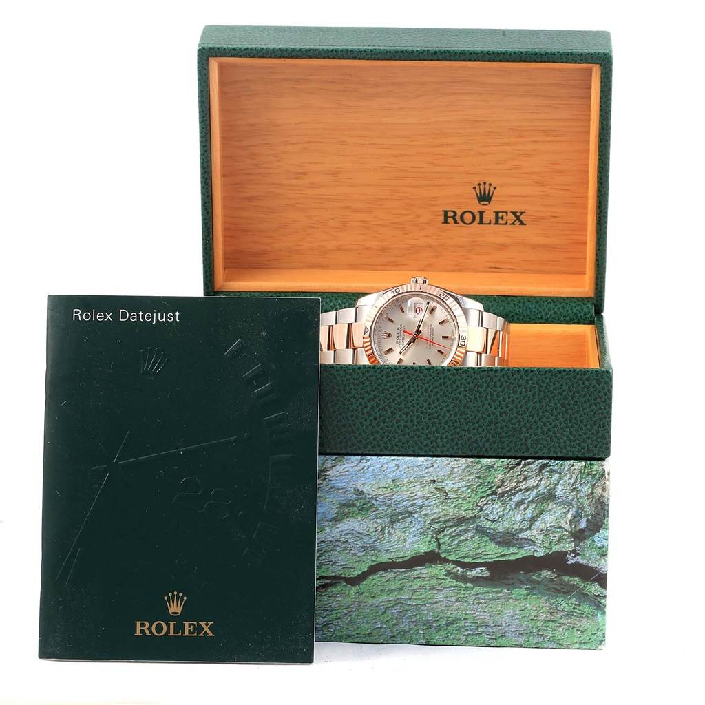 The Rolex Turn-o-Graph 116261 Men's Stainless Steel Silver Dial 116261 Men's Stainless Steel Silver Dial watch is shown front-on, placed in an open green box with a Rolex Datejust booklet.