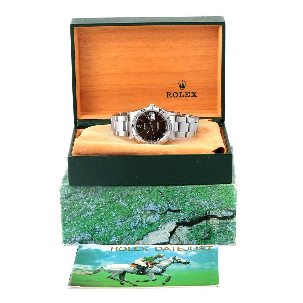 The Rolex Turn-o-Graph 16264 Men
s Stainless Steel Black Dial 16264 Men
s Stainless Steel Black Dial watch is shown from the front angle, displayed inside its open box with a manual below.