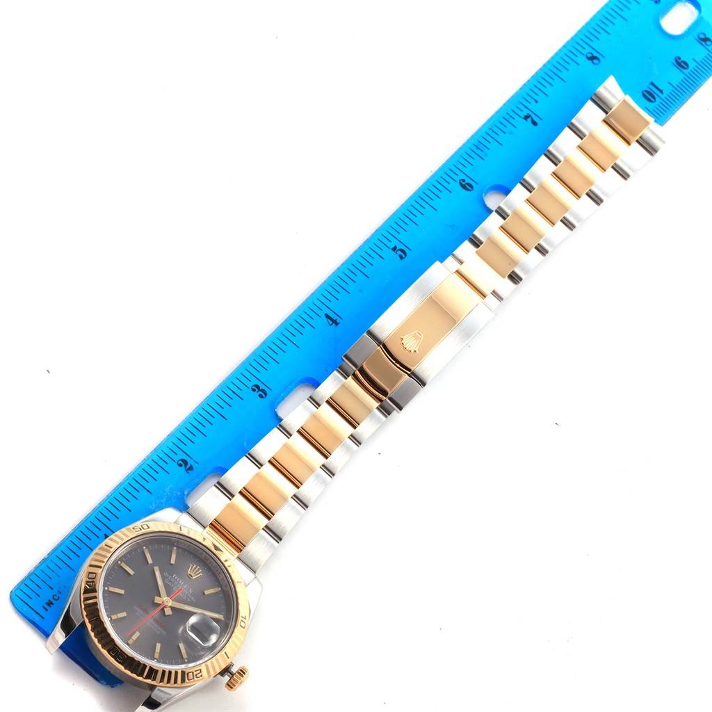 The image shows a Rolex Turn-o-Graph 116263 Men's Steel and Gold (two tone) Grey Dial 116263 Men's Steel and Gold (two tone) Grey Dial watch laid flat next to a blue ruler, highlighting the watch face and band length.