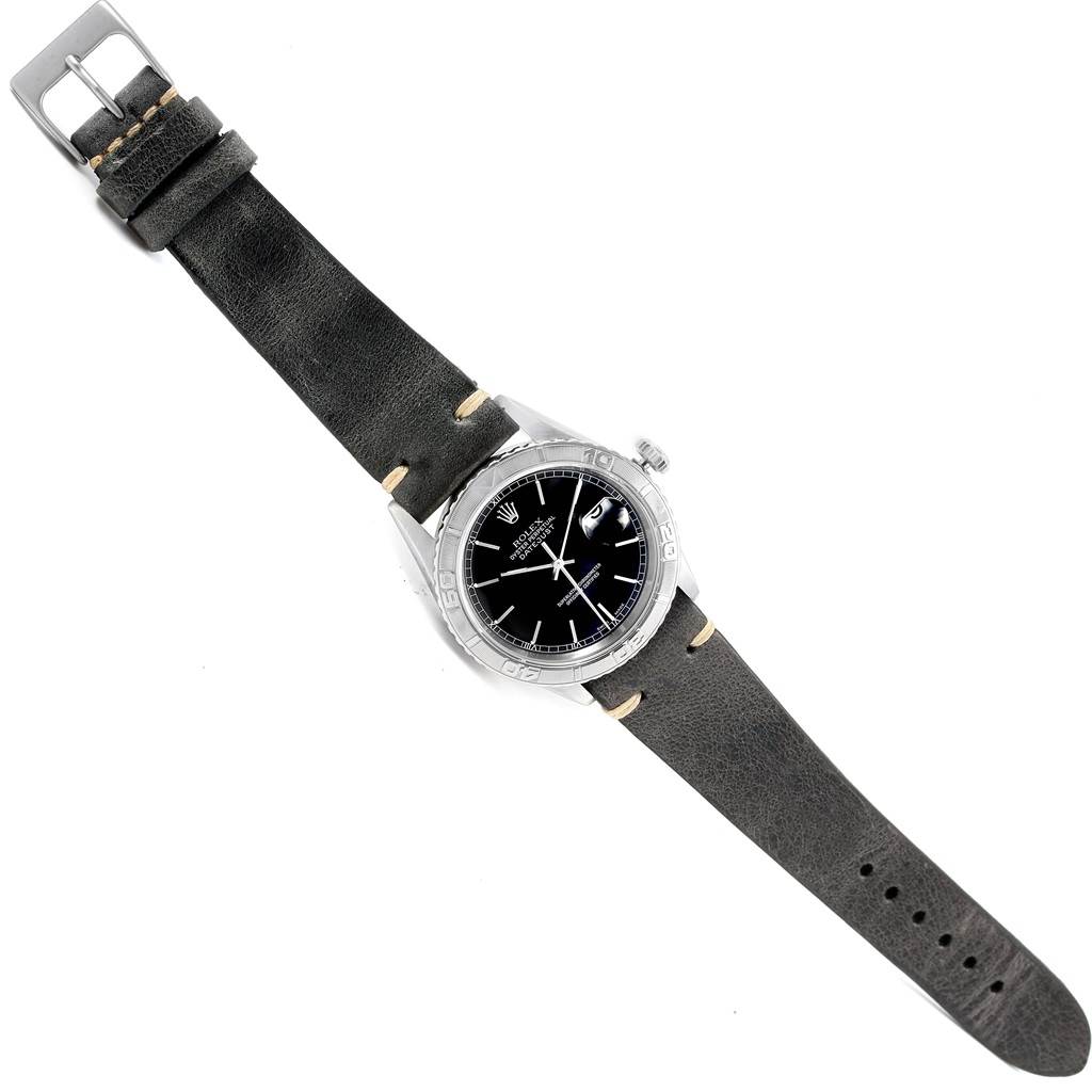 The image shows an overhead view of a Rolex Turn-o-Graph 16264 Men's Stainless Steel Black Dial 16264 Men's Stainless Steel Black Dial watch, displaying its face, bezel, crown, and leather strap.