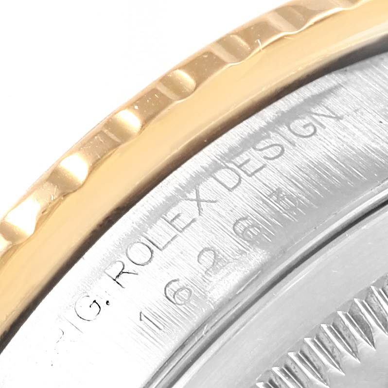 The image shows a close-up of the Rolex Turn-o-Graph 16263 Men
s Steel and Gold (two tone) Champagne Dial 16263 Men
s Steel and Gold (two tone) Champagne Dial watch
s bezel and part of the case with engraved details.