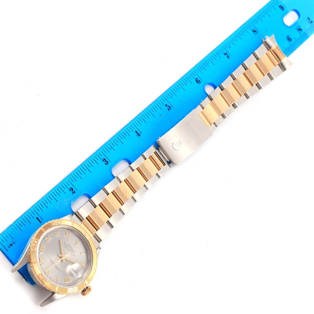 The image shows a Rolex Turn-o-Graph 16263 Men's Steel and Gold (two tone) Grey Dial 16263 Men's Steel and Gold (two tone) Grey Dial wristwatch, including its face, bezel, and full bracelet, positioned next to a blue ruler.