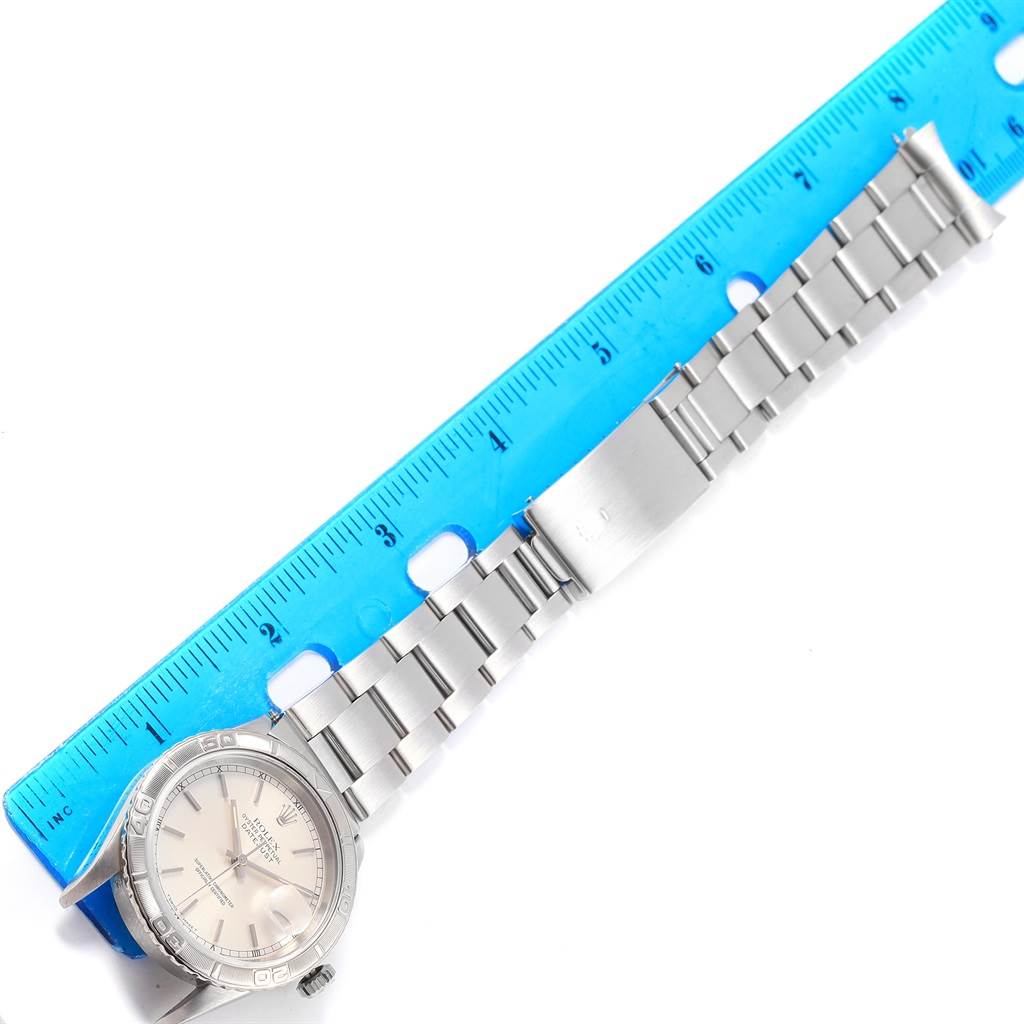 The image shows a horizontal view of a Rolex Turn-o-Graph 16264 Men's Stainless Steel Silver Dial 16264 Men's Stainless Steel Silver Dial watch, displaying its face, bezel, bracelet, and a ruler for scale.