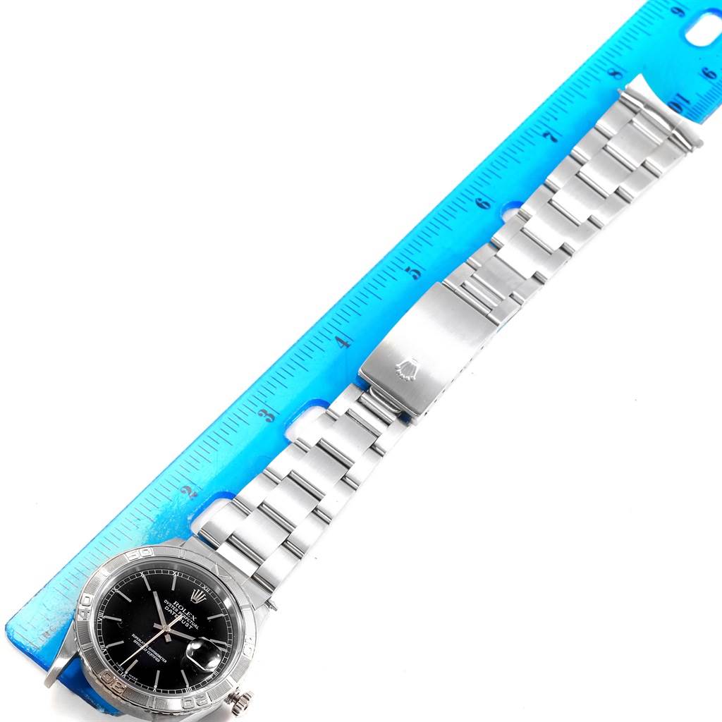 This image shows a Rolex Turn-o-Graph 16264 Men's Stainless Steel Black Dial 16264 Men's Stainless Steel Black Dial watch laid flat next to a ruler, displaying its bracelet, clasp, and face.