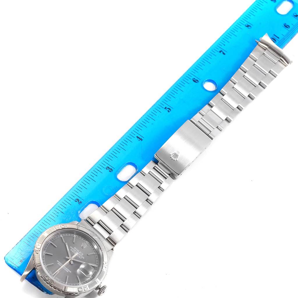 This image shows a Rolex Turn-o-Graph 16264 Men's Stainless Steel Grey Dial 16264 Men's Stainless Steel Grey Dial watch from a top-down angle, highlighting the face, bezel, and metal bracelet next to a ruler.