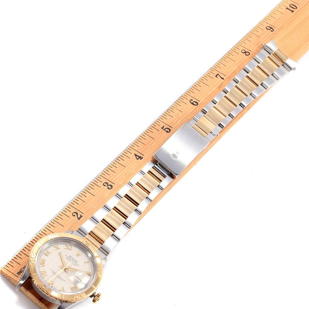 The Rolex Turn-o-Graph 16263 Men
s Steel and Gold (two tone) Beige Dial 16263 Men
s Steel and Gold (two tone) Beige Dial watch is shown from an overhead angle, displaying its face, bezel, and entire bracelet with a ruler for scale.