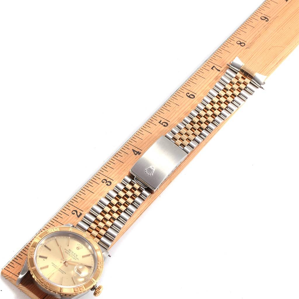 The image shows a Rolex Turn-o-Graph 16263 Men's Steel and Gold (two tone) Champagne Dial 16263 Men's Steel and Gold (two tone) Champagne Dial watch laid flat on a wooden ruler, highlighting its bezel, dial, and metal bracelet with clasp.