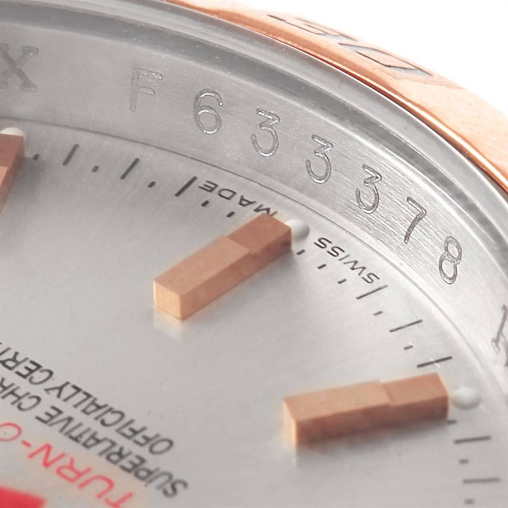 This close-up shot of a Rolex Turn-o-Graph 116261 Men
s Stainless Steel Silver Dial 116261 Men
s Stainless Steel Silver Dial watch captures part of the dial, markers, and the engraved serial number.