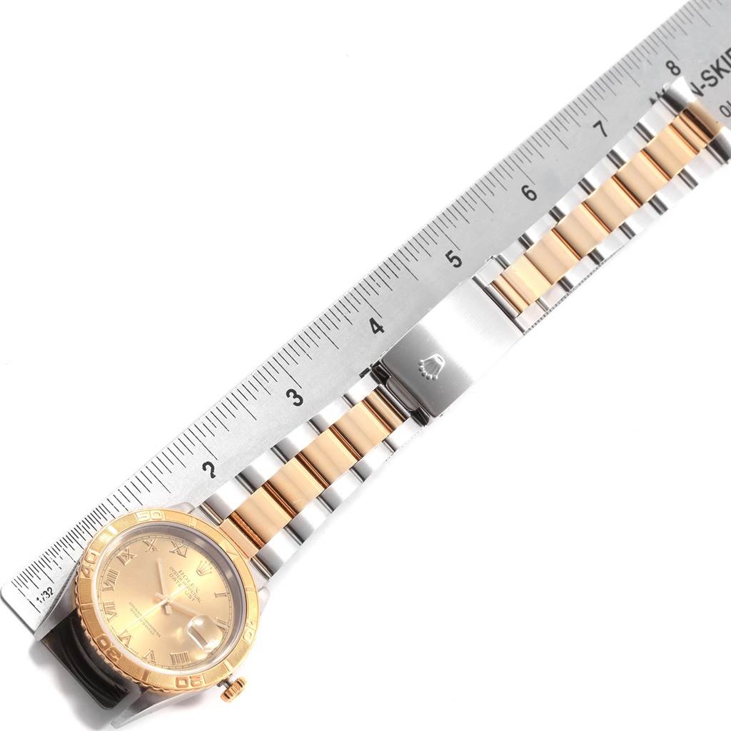 The Rolex Turn-o-Graph 16263 Men's Steel and Gold (two tone) Champagne Dial 16263 Men's Steel and Gold (two tone) Champagne Dial watch is displayed flat, showing the dial, bezel, and metal bracelet placed next to a ruler for scale.