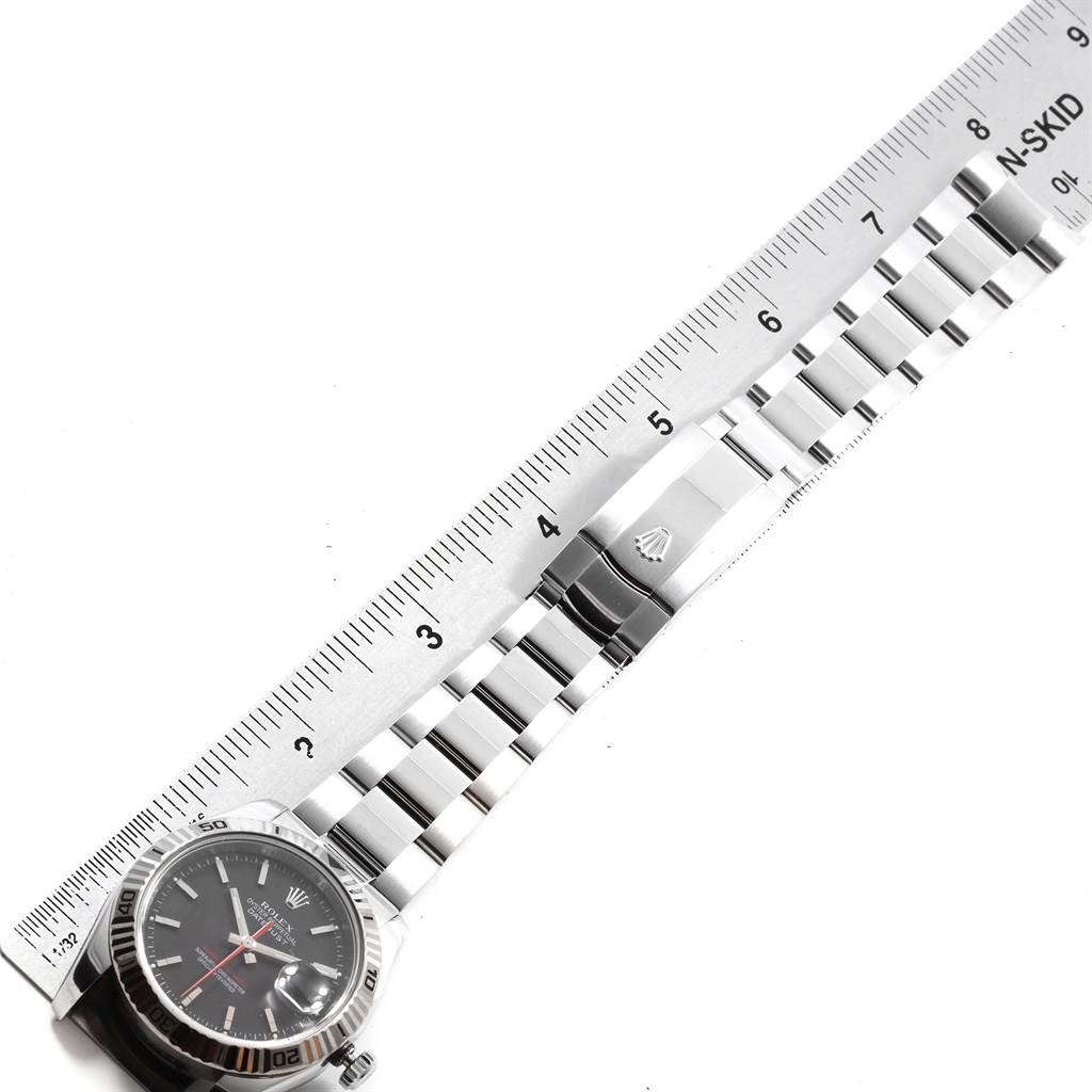 The image shows a Rolex Turn-o-Graph 116264 Men
s Stainless Steel Black Dial 116264 Men
s Stainless Steel Black Dial watch laid flat beside a ruler, displaying its face, bezel, bracelet, and clasp.
