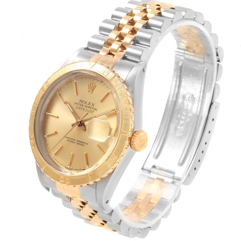 The image shows an angled view of a Rolex Turn-o-Graph 16253 Men
s Steel and Gold (two tone) Champagne Dial 16253 Men
s Steel and Gold (two tone) Champagne Dial watch highlighting its gold dial, gold bezel, and two-tone metal bracelet.