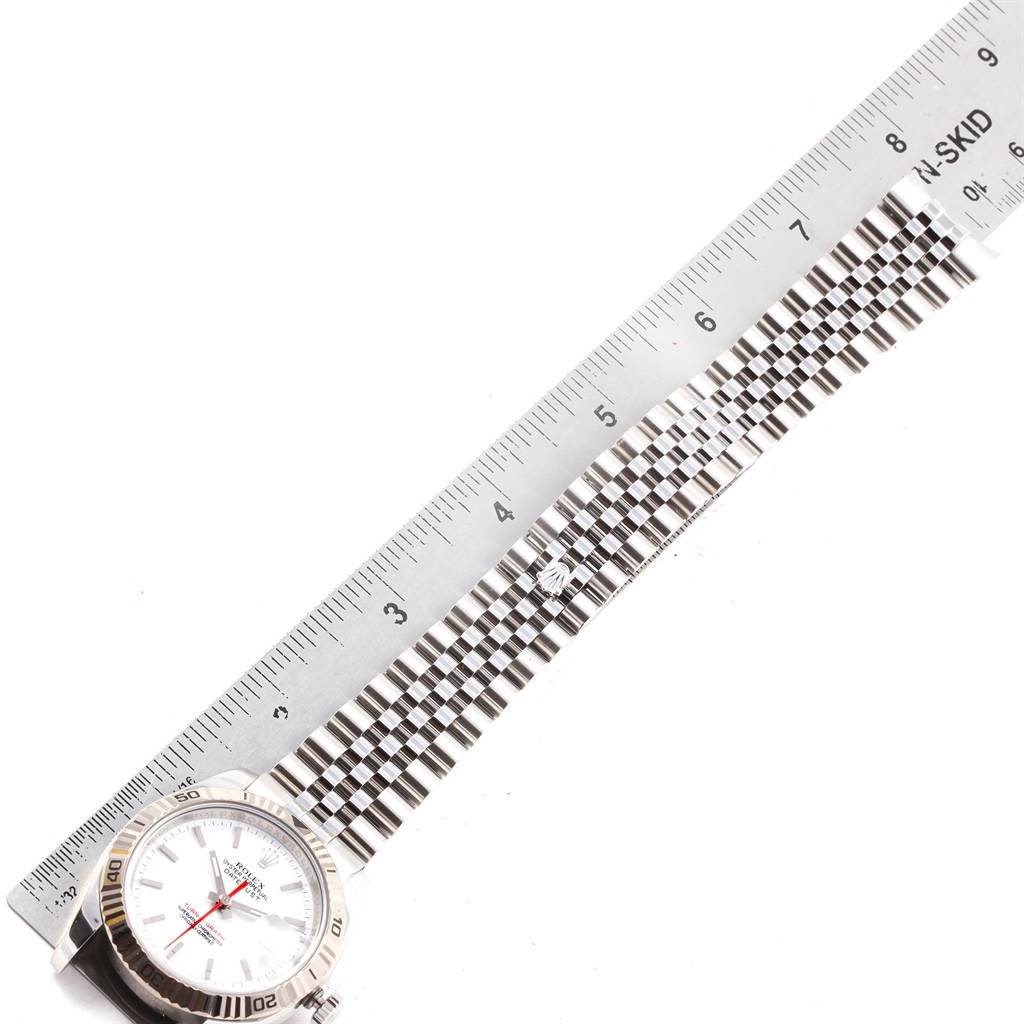 The image shows a top-down view of the Rolex Turn-o-Graph 116264 Men
s Stainless Steel White Dial 116264 Men
s Stainless Steel White Dial watch, highlighting its face, bezel, and bracelet alongside a ruler.