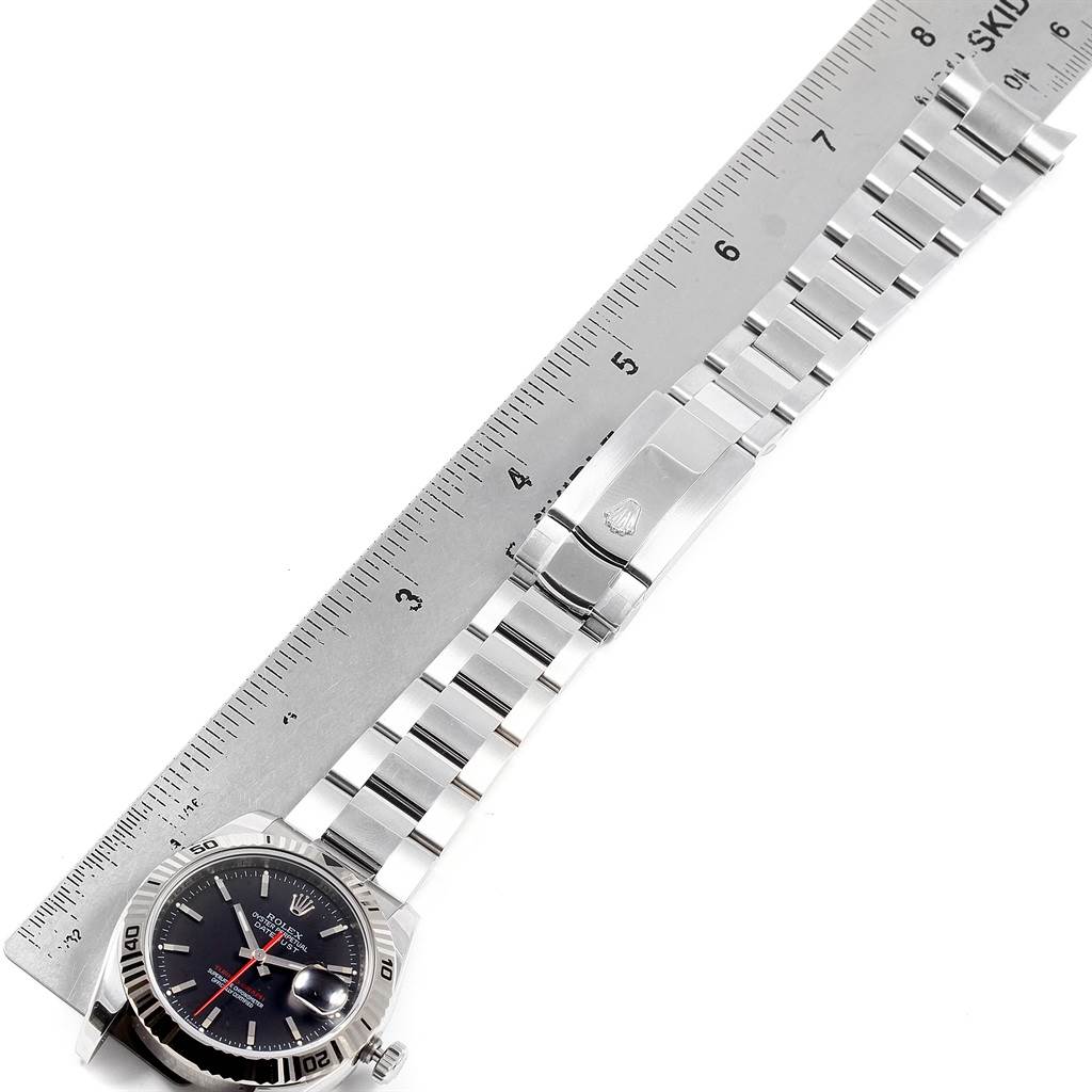 The image shows a Rolex Turn-o-Graph 116264 Men
s Stainless Steel Black Dial 116264 Men
s Stainless Steel Black Dial watch laid flat next to a ruler, displaying the face, bracelet, and clasp in a top-down view.