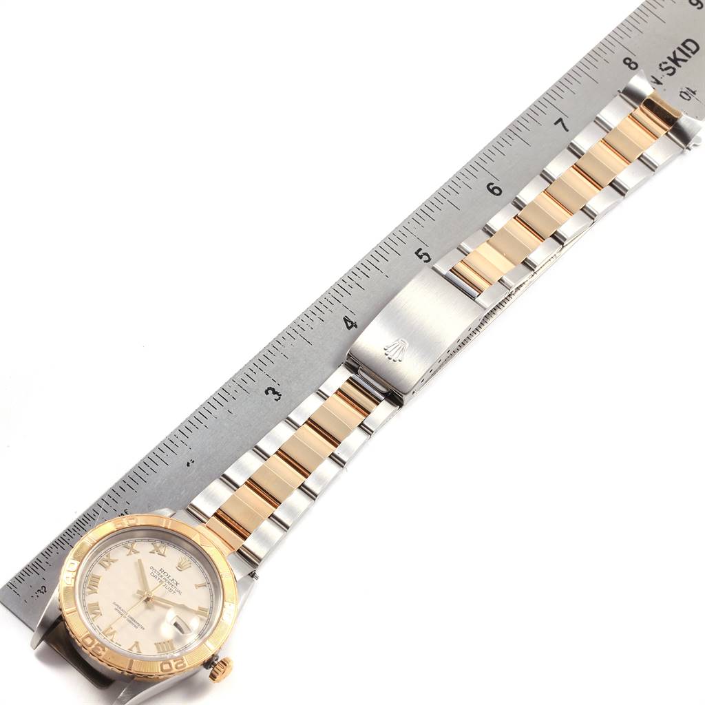 This image shows a top-down view of a Rolex Turn-o-Graph 16263 Men's Steel and Gold (two tone) Beige Dial 16263 Men's Steel and Gold (two tone) Beige Dial watch with a two-tone metal bracelet placed next to a ruler.
