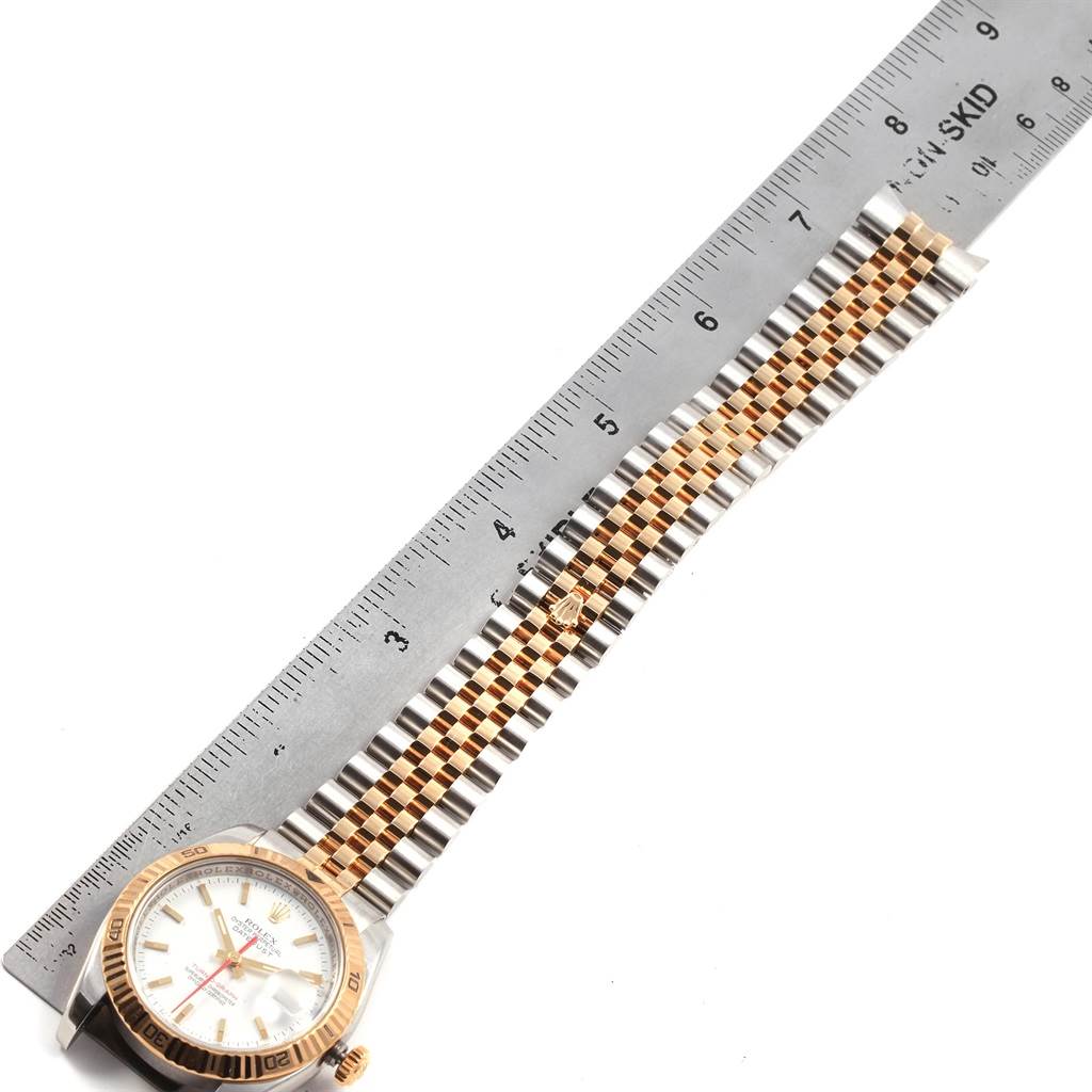 This image shows a Rolex Turn-o-Graph 116263 Men
s Stainless Steel White Dial 116263 Men
s Stainless Steel White Dial model watch laid flat, with a two-tone bracelet beside a ruler.